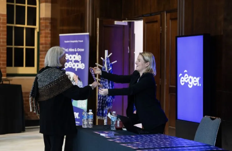 Registration desk with glowing eeger. sign and lanyard check-in at the Eeger roadshow
