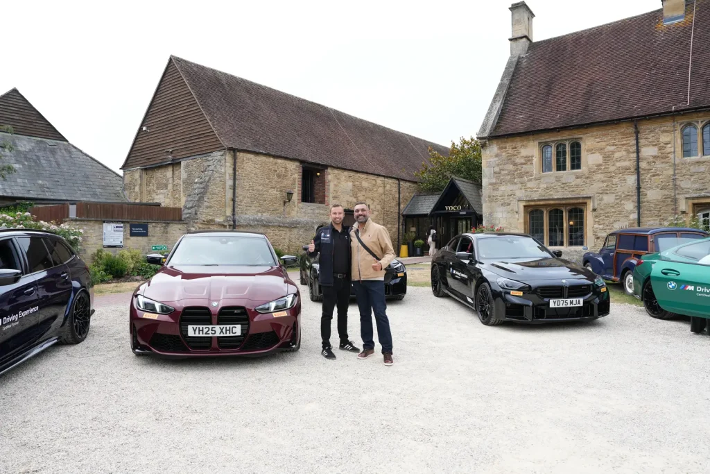 Two Men Standing In Front Of Bmw Cars At